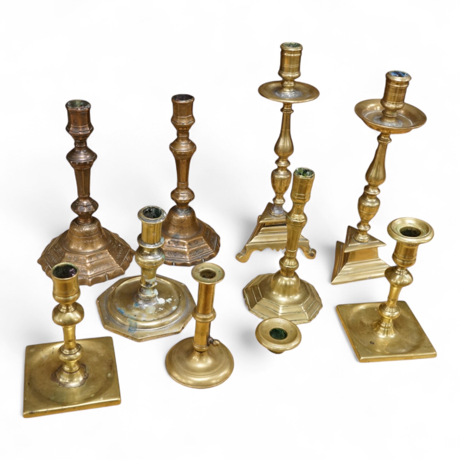 A group of period brass candlesticks, the majority 18th century